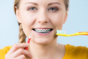 girl brushing teeth with braces